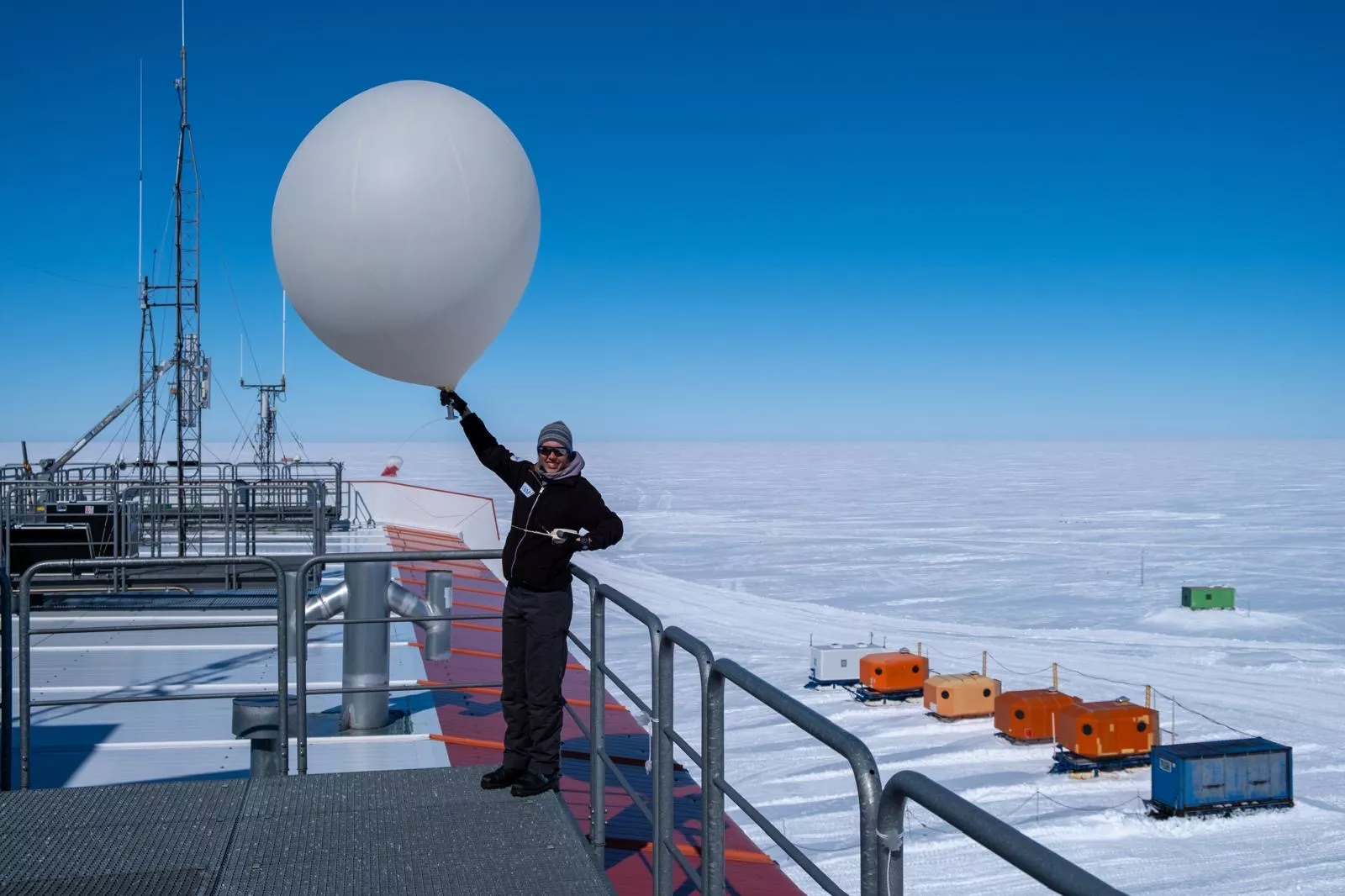 Meteorologin Gina lässt einen Wetterballon in der Antarktis steigen. Sie steht auf dem Dach der deutschen Forschungsstation Neumayer 3 in der Antarktis